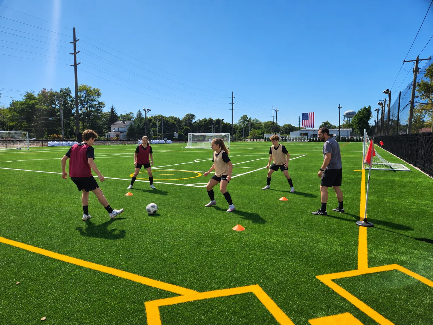 Event illustration: intermediate soccer players practice passing and receiving at the club’s two-field venue.